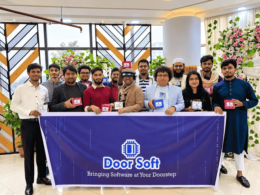 Door Soft team holding the Door Soft banner at a company celebration